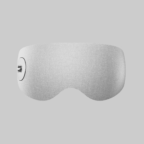 A light grey fabric far-infrared hot and cold eye massager with a textured mesh pattern and a small circular control on the left side.